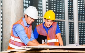 Workers reviewing plans on a construction site